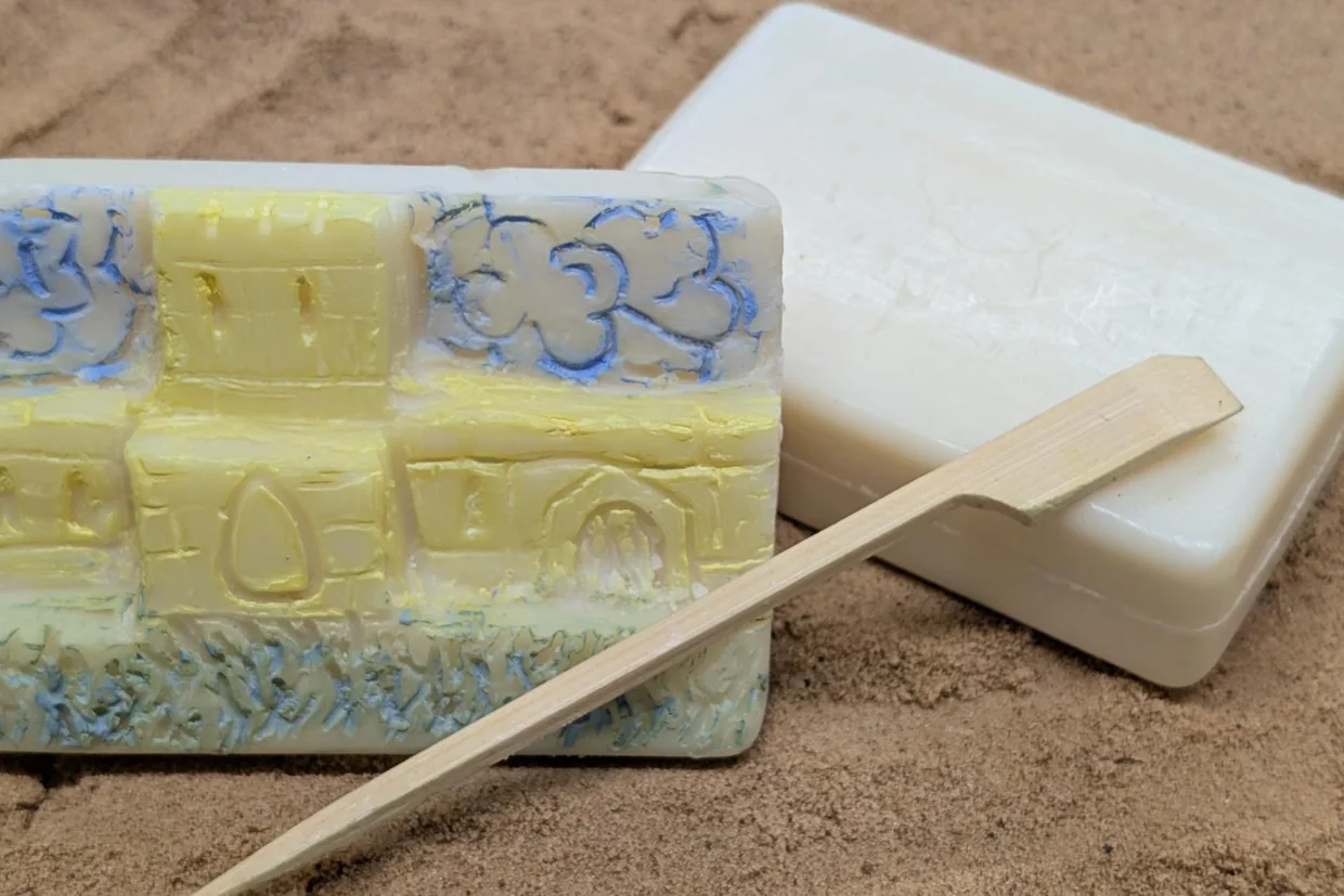 This image shows an image of a cathedral carved into a bar of soap with a carving tool.